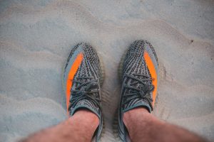 person wearing black and yellow running shoes