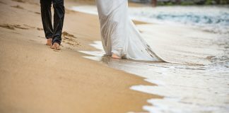 Florida Beach Weddings: Let’s Talk Sand, Scenery & Wildlife man in white dress shirt and blue denim jeans walking on beach during daytime